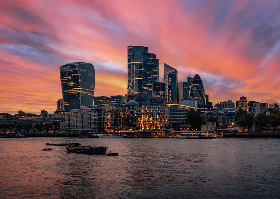 Boats on the River Thames beneath the London skyline at sunset